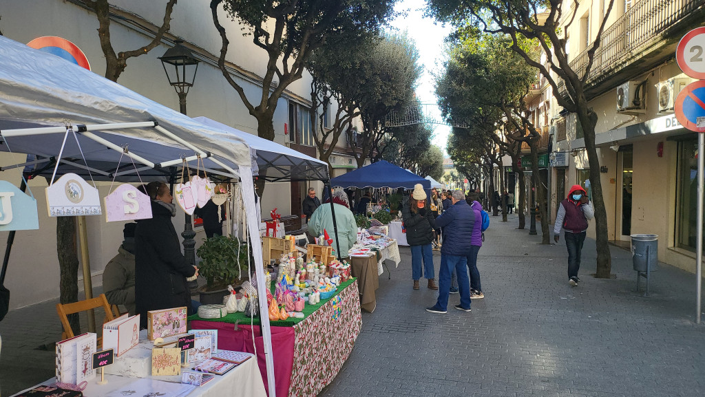 Parades d'artesanies amb persones passejant i comprant