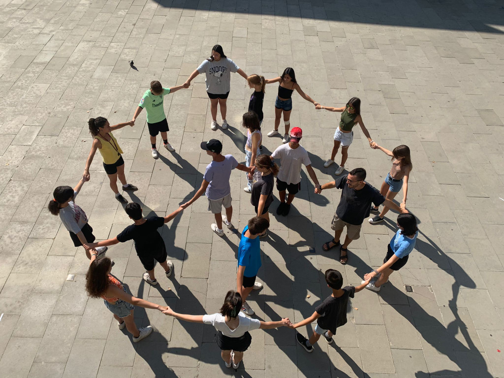 Grup de joves agafats de les mans fent una espiral