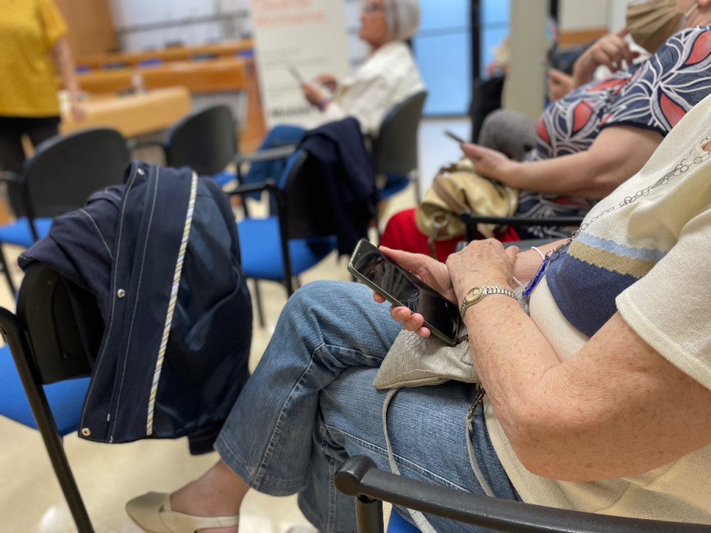 Persones assistents a la Xerrada de la Sala de Plens amb el mòbils a la mà