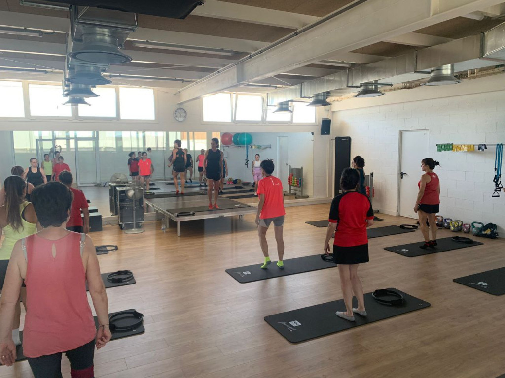 Sala de pilates amb persones fent exercici