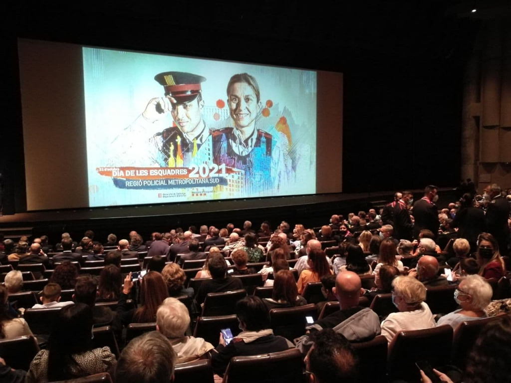 Assistents al Teatre de la Passió amb una pantalla gegant a l'escenari