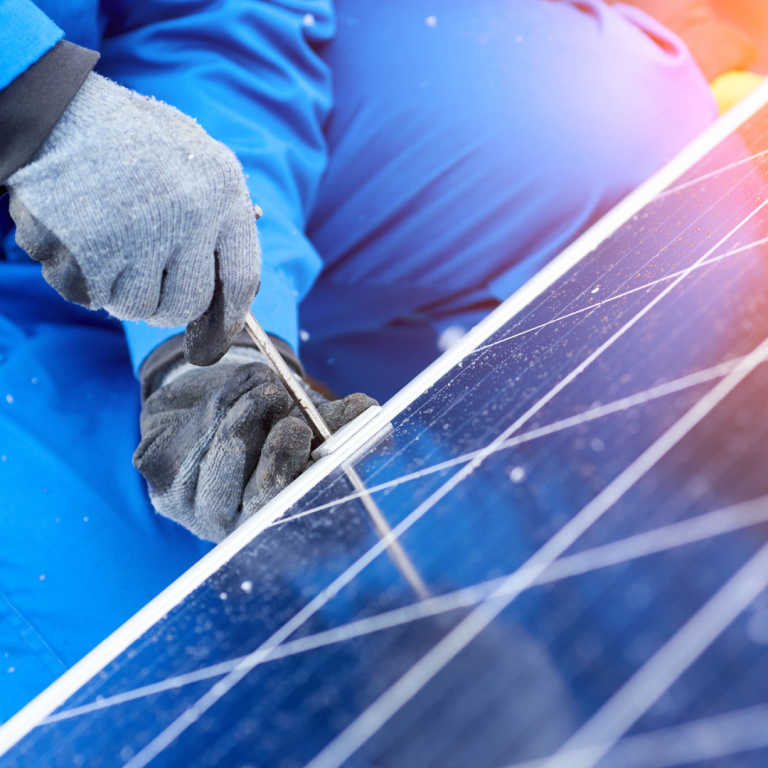 Imatge d'unes mans treballant en una placa fotovoltaica