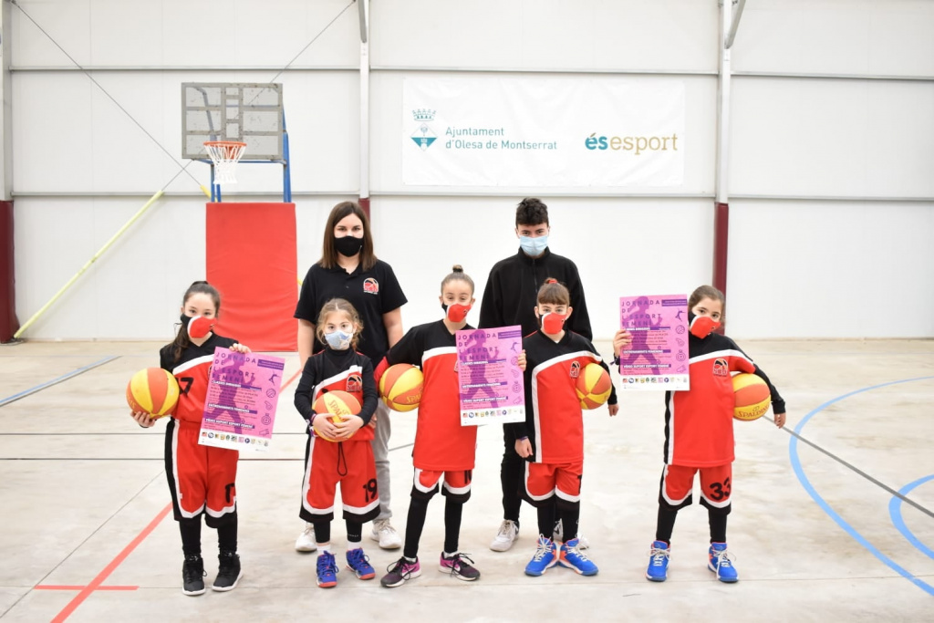 Equip femení de nenes en la Jornada d'Esport ensenyant el cartell de les jornades